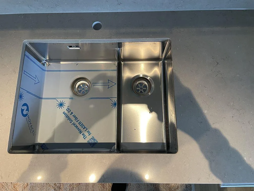 Köksbänkskiva i Silestone Coral Clay, polerad kvartskomposit i varm beige, med underlimmad rostfri diskho i ett kök i Älta.