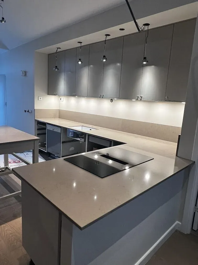 Polerad köksö och bänkrad i Silestone Coral Clay i ett kök under montering i Ängelholm.