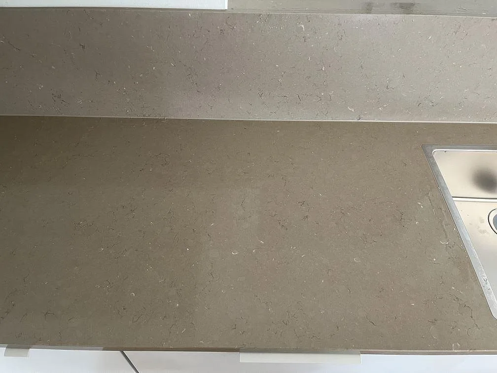 Köksbänkskiva i Silestone Coral Clay med rostfri diskho och uppvikt stänkkant i greige komposit i Båstad.
