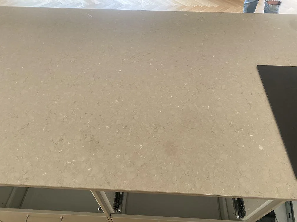 Polerad Silestone Coral Clay köksbänkskiva i Båstad med synlig stenstruktur och svart häll vid kanten.