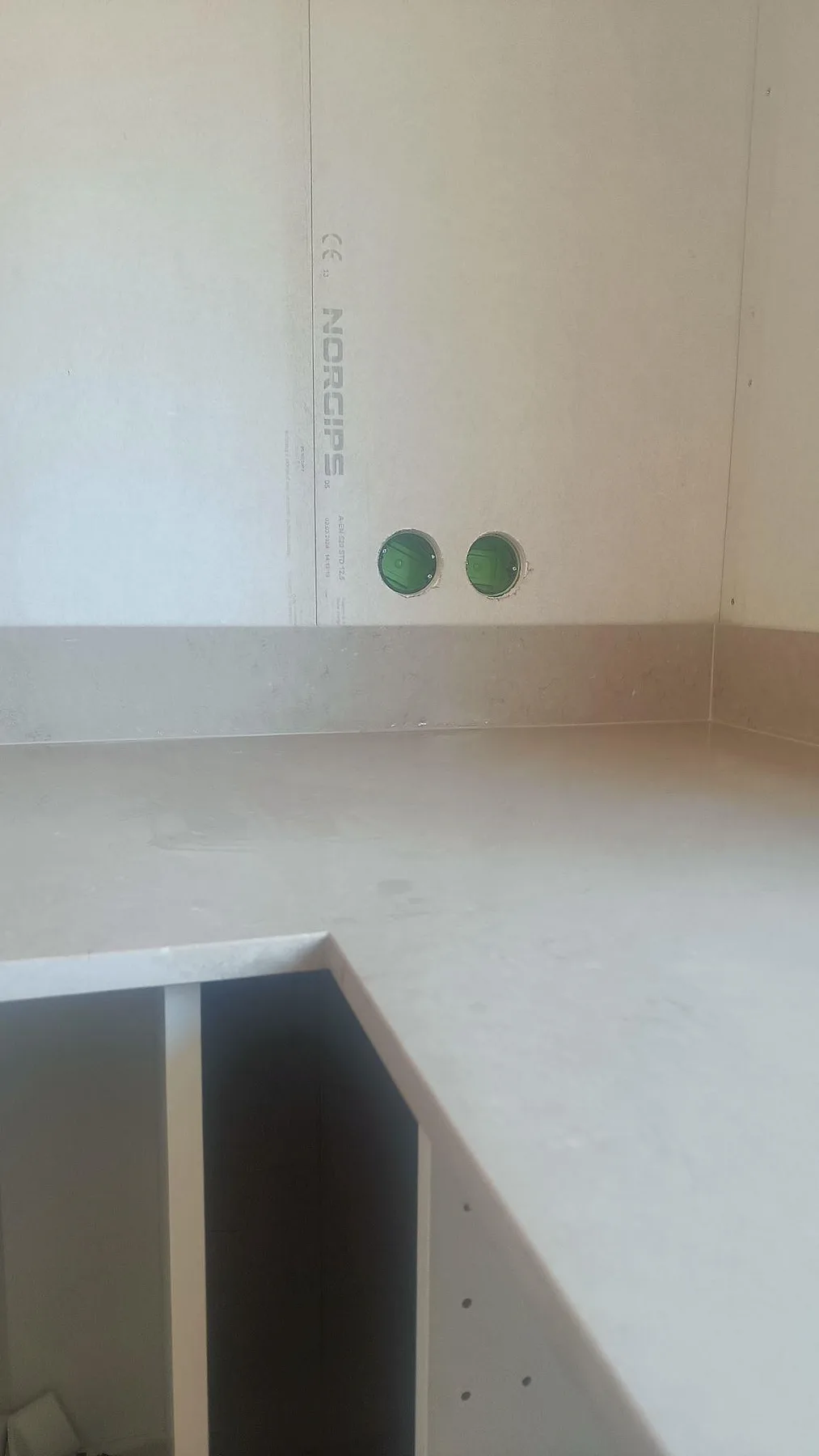 Porträttbild av matt Silestone Coral Clay bänkskiva med stänkskydd och öppna köksstommar i Båstad.