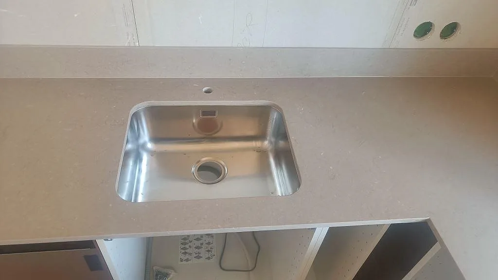 Rostfri underlimmad diskho monterad i matt Silestone Coral Clay bänkskiva med stänkskydd i Båstad.