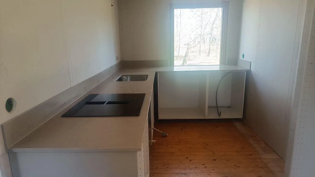 Köksbänkskiva i matt Silestone Coral Clay med svart häll, rostfri underlimmad diskho och uppvikt stänkskydd i Båstad.