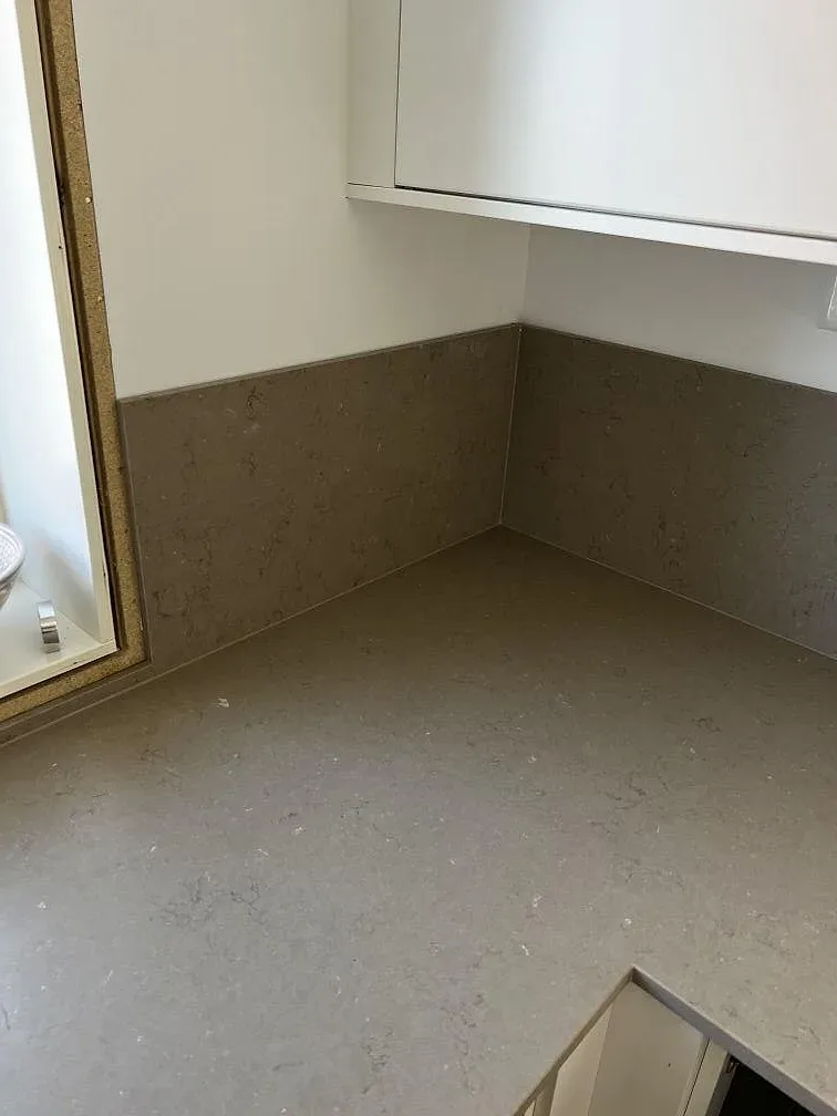Uppvikt stänkkant och köksbänkskiva i Silestone Coral Clay med matt lerton i ett kök i Barsebäck.
