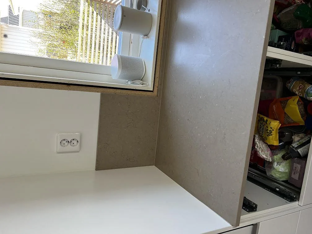 Fönsterbänk och stänkskydd i Silestone Coral Clay med matt yta vid köksfönstret i Barsebäck.