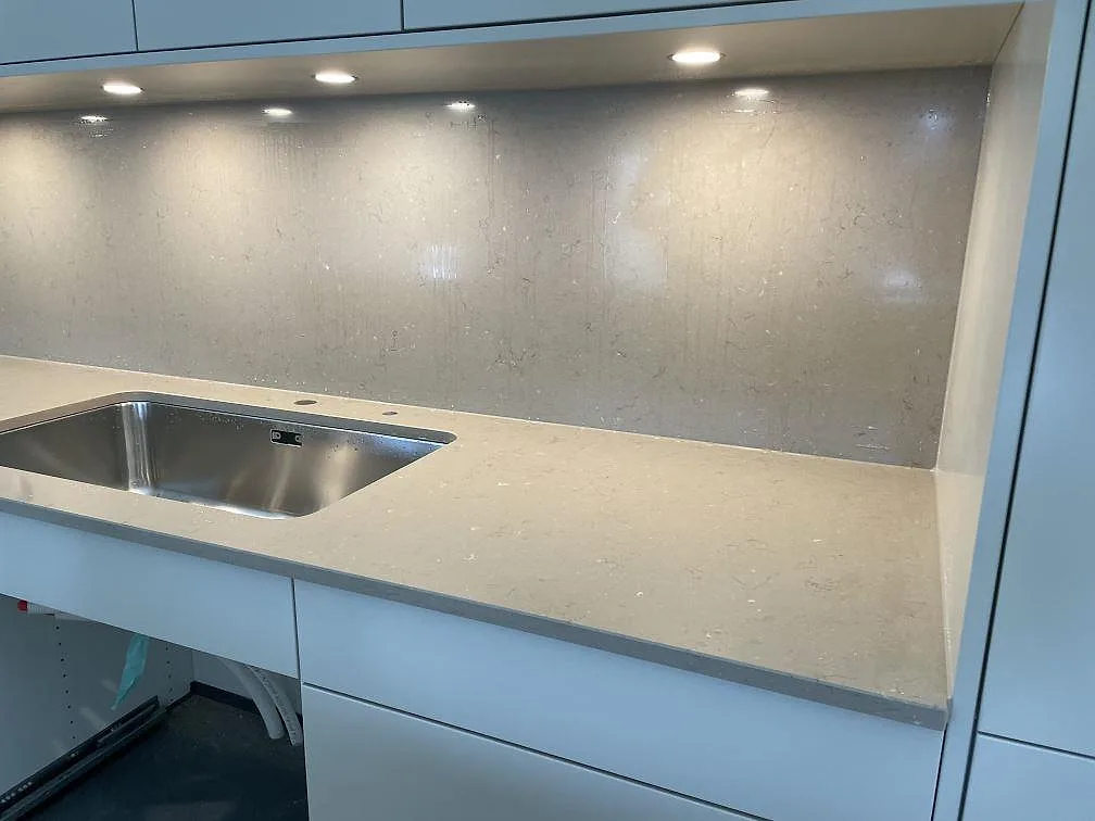 Köksbänkskiva i Silestone Coral Clay komposit med rostfri diskho och matchande stänkskydd i ett ljust kök i Bjärred.