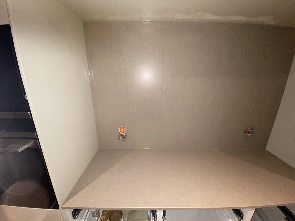 Arbetsbänk i Silestone Coral Clay med heltäckande väggbeklädnad i samma sten i ett kök i Borås.