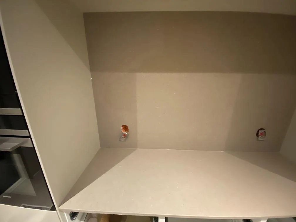Köksö i Silestone Coral Clay med matt Mocka-yta, infälld induktionshäll och underlimmad rostfri diskho i ett kök under montering i Borås.
