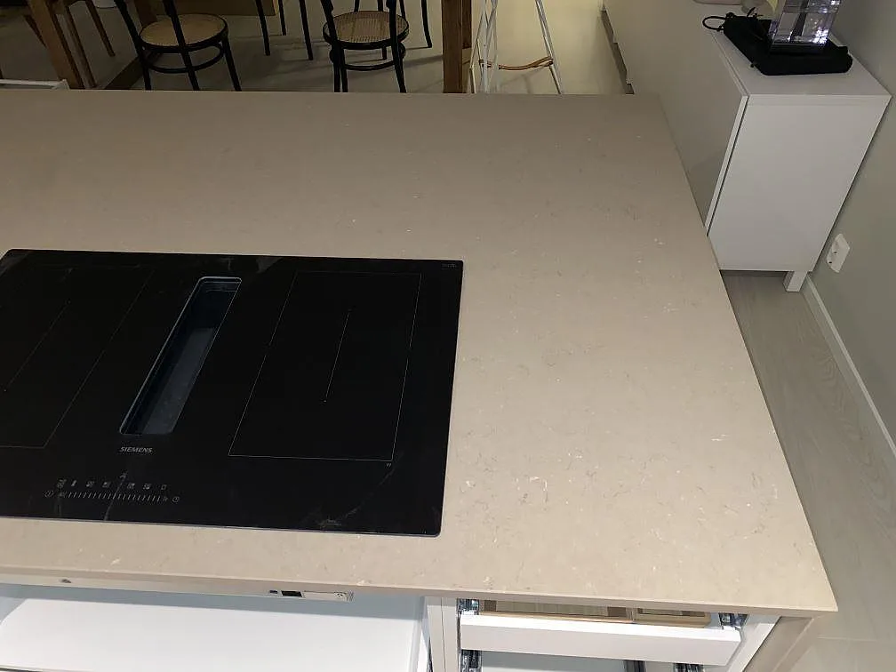Köksö i greige Silestone Coral Clay med infälld Siemens induktionshäll, mitt under montering i Borås