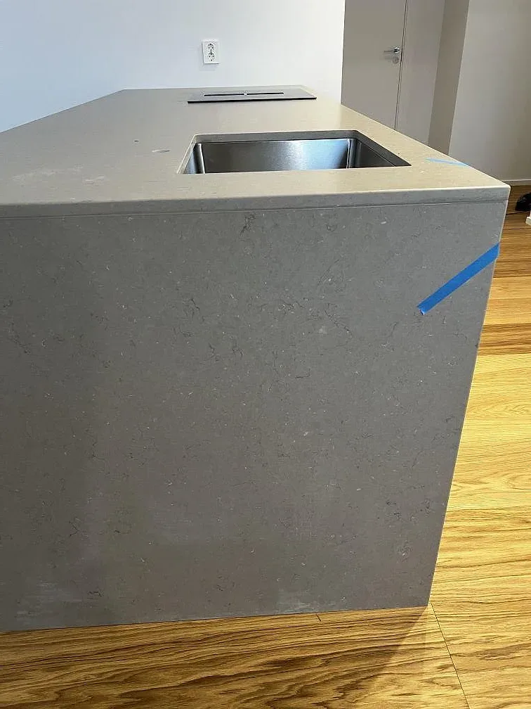 Detaljbild av den varma gråbeige Silestone Coral Clay-skivan på en köksö i Borås.