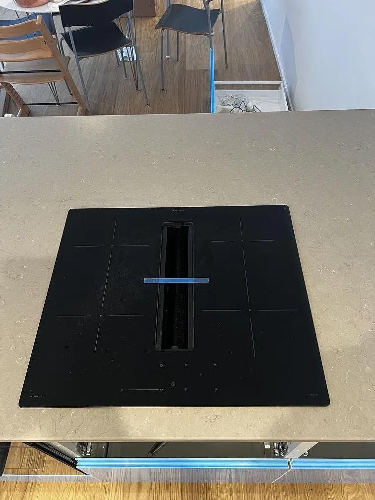 Svart häll infälld i en köksbänkskiva av Silestone Coral Clay med matt yta i Borås.