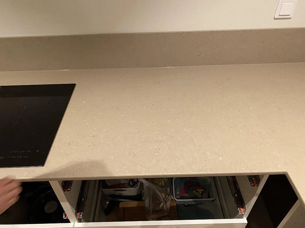 Monteringsbild av köksbänkskiva i polerad Silestone Coral Clay vid hällsidan, med uppvikt stänkkant i Borås.