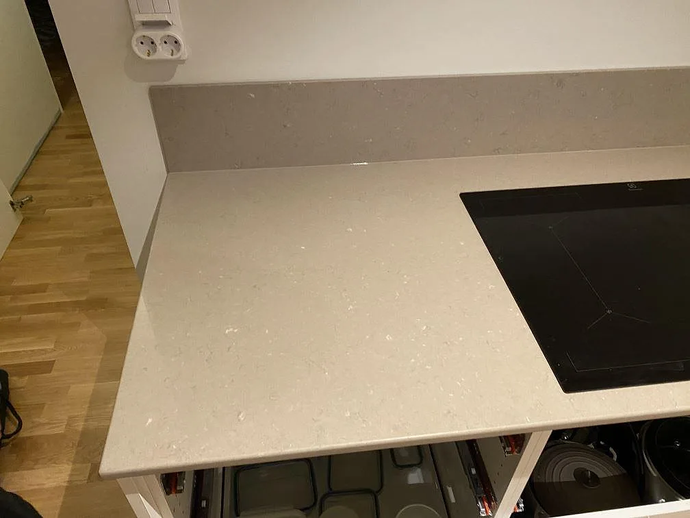 Sidoyta med infälld häll i polerad Silestone Coral Clay, installerad som köksbänkskiva med stänkkant i Borås.