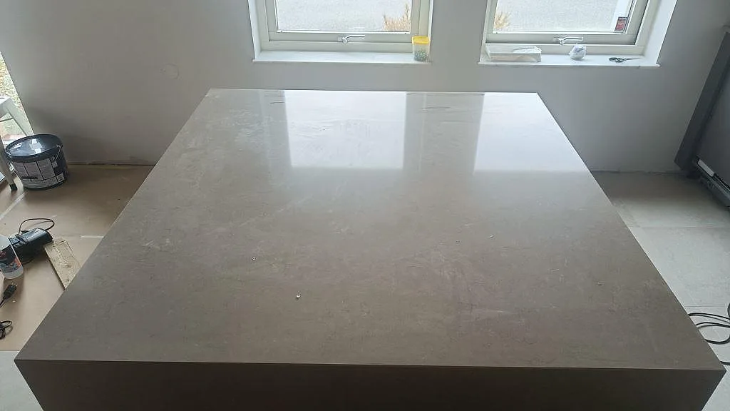 Polerad köksö i Silestone Coral Clay, greige kvartskomposit, ovanifrån i ett kök under montering i Bunkeflostrand.