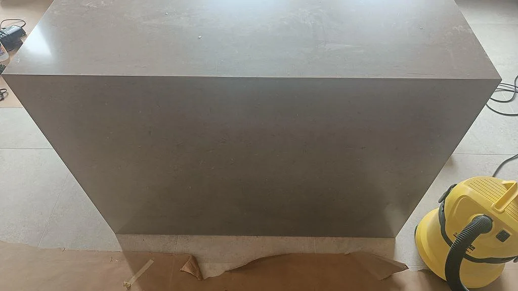 Köksö i polerad Silestone Coral Clay med blanka reflektioner i taupe kvartskomposit, fotograferad mot fönstret i ett kök under inredning i Bunkeflostrand.