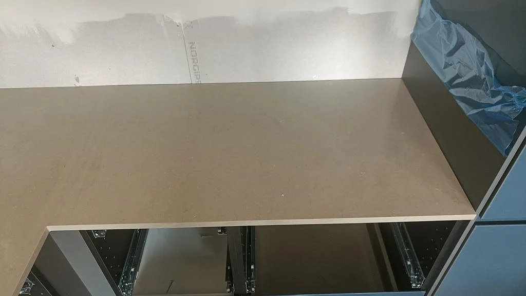 Köksö i Silestone Coral Clay, polerad greige kvartskomposit, sedd ovanifrån i ett kök under inredning i Bunkeflostrand.