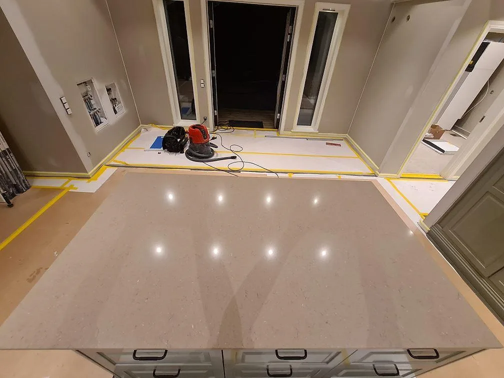Närbild av polerad Silestone Coral Clay som köksöyta med varm gråbeige ton och speglingar i Enköping.