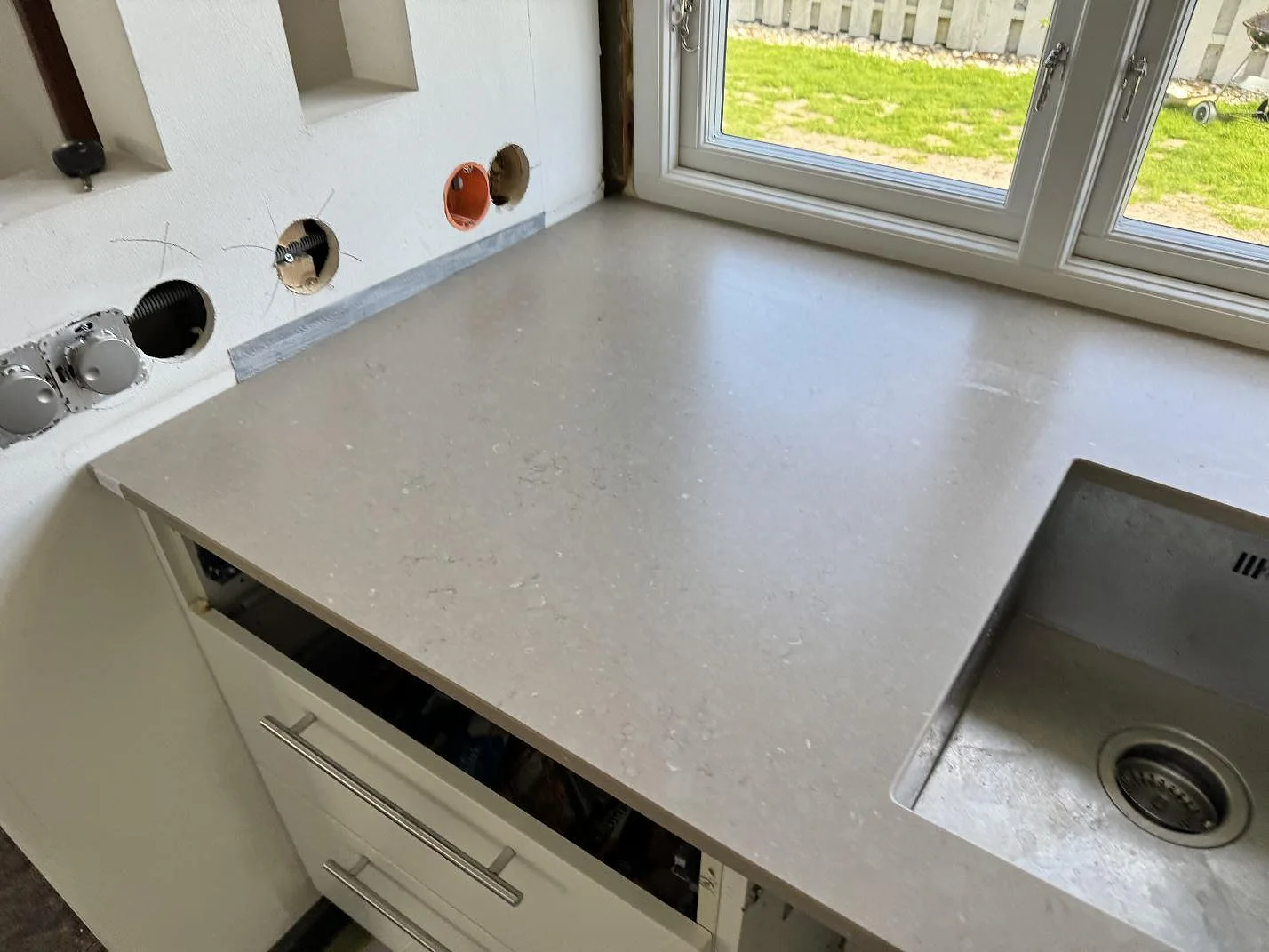 Detalj av Silestone Coral Clay med matt yta vid fönster och underlimmad rostfri diskho i Falsterbo.