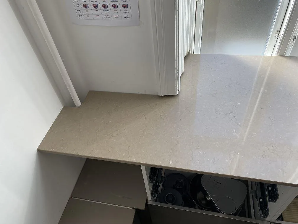 Detalj av vänster bänkrad i polerad Silestone Coral Clay, komposit, med ådrad yta i kök i Frederiksberg c.