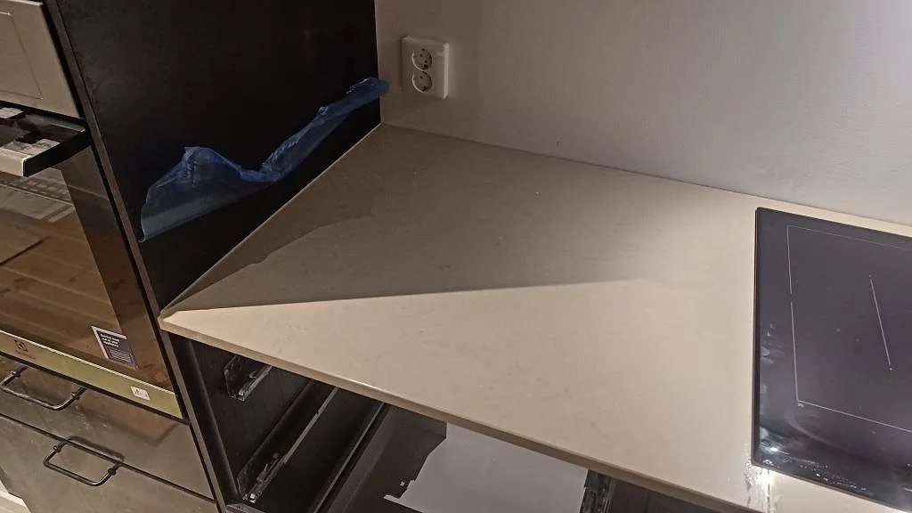 Vänster del av köksbänkskiva i polerad Silestone Coral Clay med varm gråbeige ton i Gärsnäs.