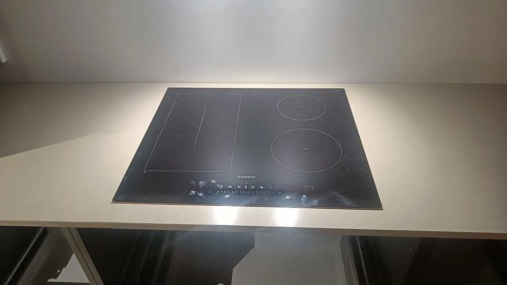 Häll infälld i en 20 mm polerad köksbänkskiva av Silestone Coral Clay komposit i Gärsnäs.