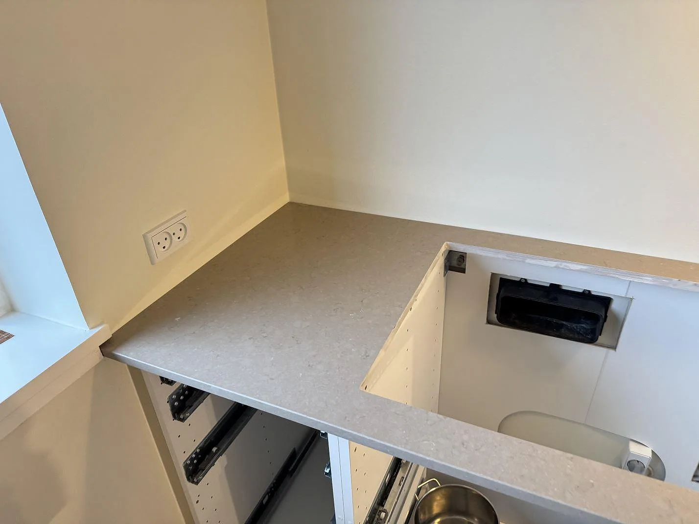 Hörndel av köksbänkskiva i Silestone Coral Clay, polerad varm greige kvartskomposit, med bearbetat urtag och ljusa stommar i Ganløse.