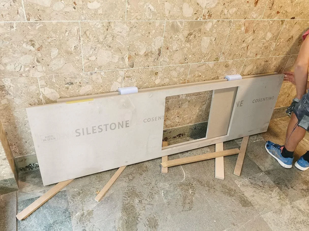 Färdigkapad bänkskiva i varm beige Silestone Coral Clay med urtag för diskho, på bockar inför montering i Göteborg.