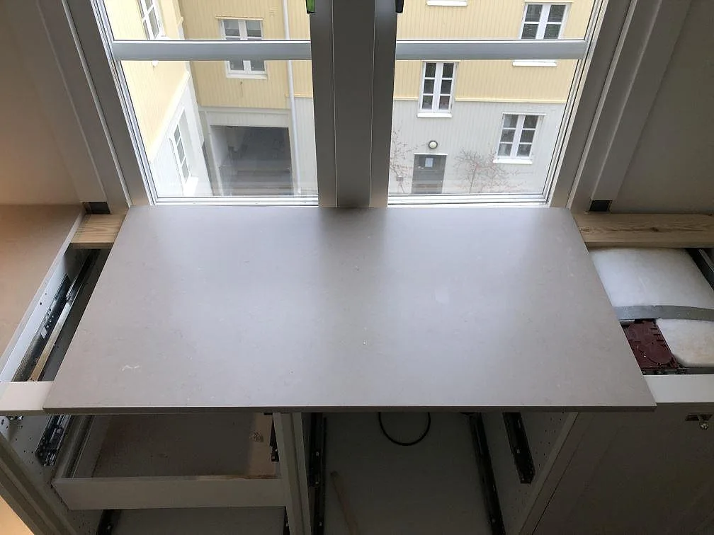 Installerad Silestone Coral Clay bänkskiva i greige kvartskomposit vid ett fönster i ett kök under montering i Göteborg.