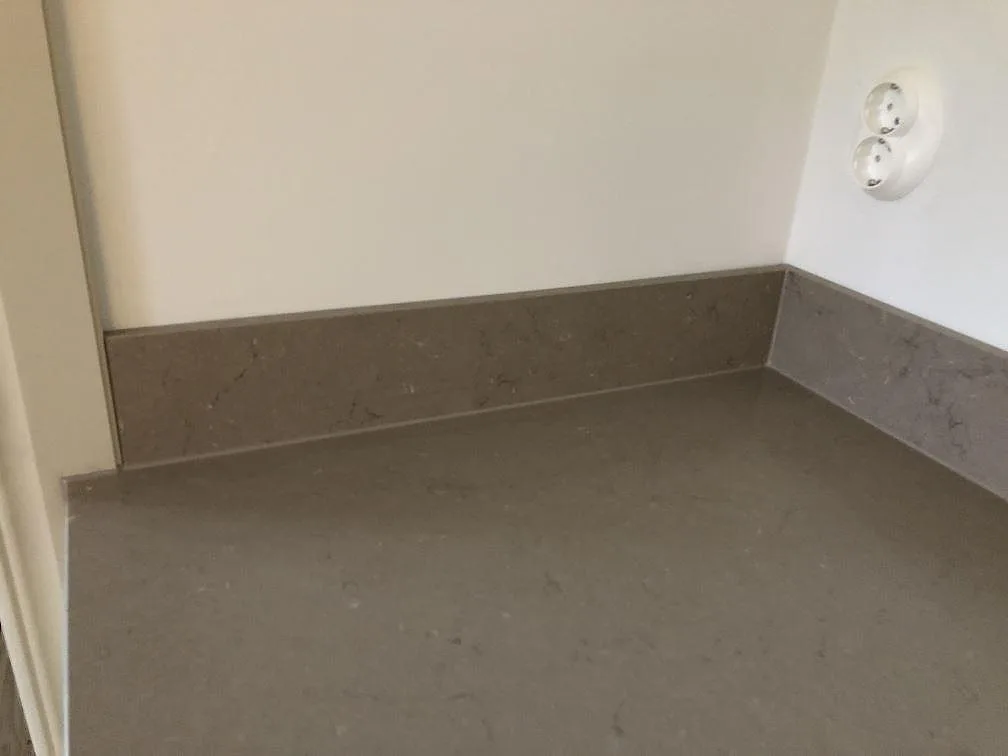 Detalj av matt Silestone Coral Clay med uppvikt stänkkant och greige ådring i ett kök i Göteborg.