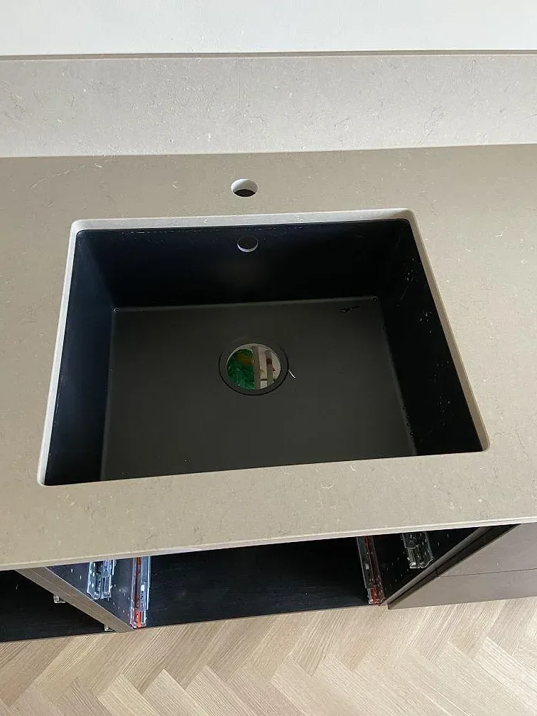 Underlimmad komposithoa i mörk antracit i polerad Silestone Coral Clay köksbänkskiva med förborrade blandarhål i Göteborg.