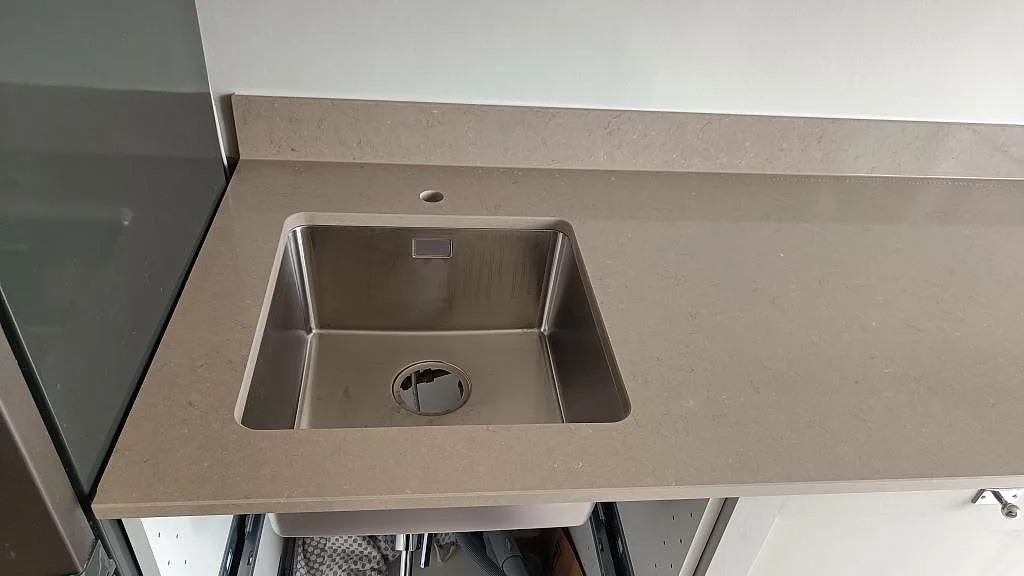 Polerad Silestone Coral Clay bänkskiva i komposit med rostfri diskho och låg stänkkant i Göteborg.