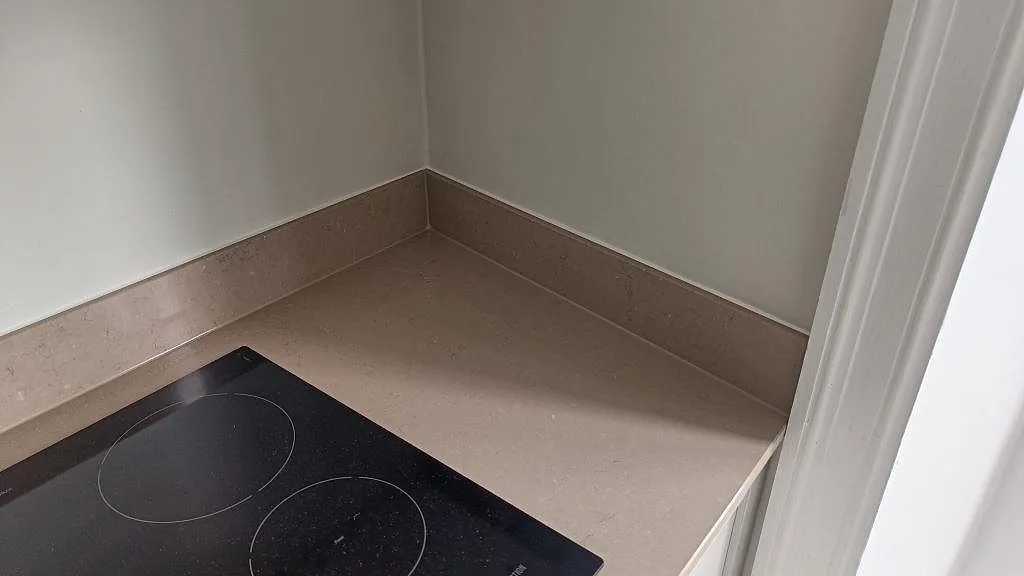Hörndel av köksbänkskiva i polerad Silestone Coral Clay komposit med häll och stänkkant i Göteborg.