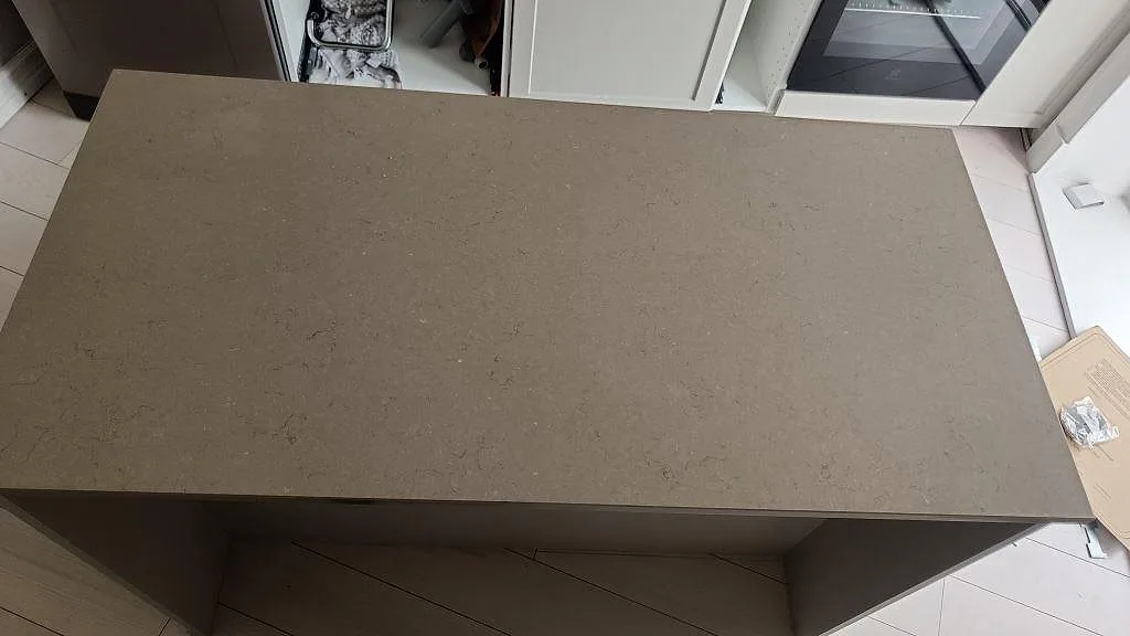 Köksö i polerad Silestone Coral Clay sedd ovanifrån, greige kvartskomposit i ett kök i Göteborg.