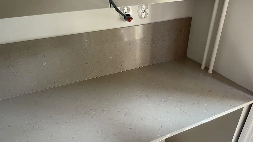 Rak köksbänkskiva i polerad Silestone Coral Clay komposit med matchande stänkskydd, öppen diskhoutsågning och underlimmad rostfri diskho i Göteborg.
