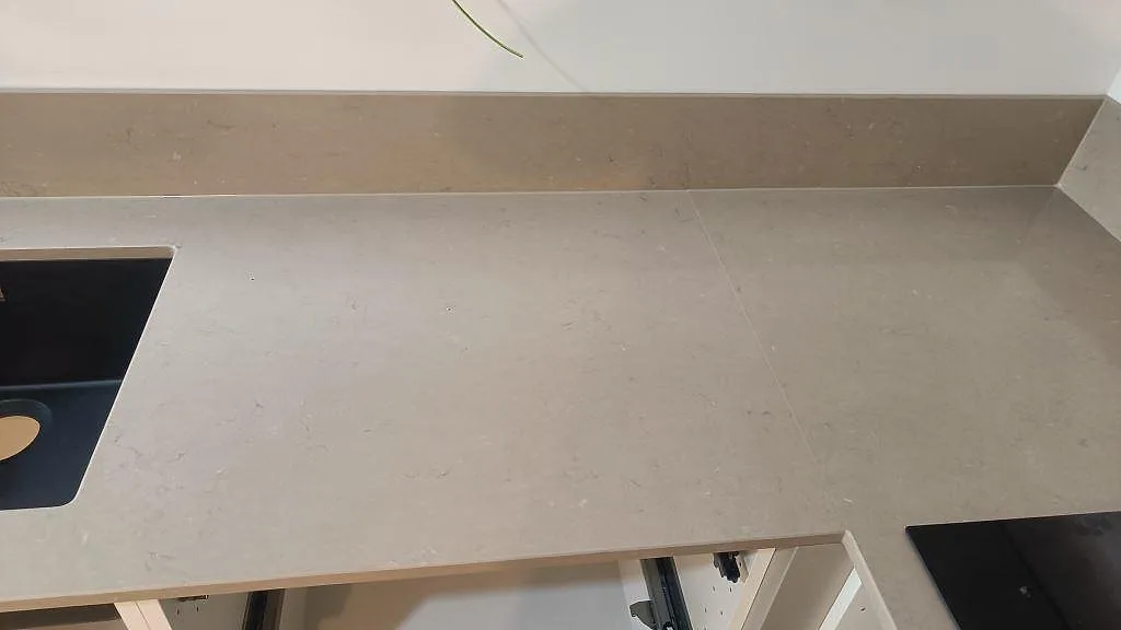Sammanhängande arbetsyta i polerad Silestone Coral Clay mellan diskho och häll, med låg stänkkant i Göteborg.