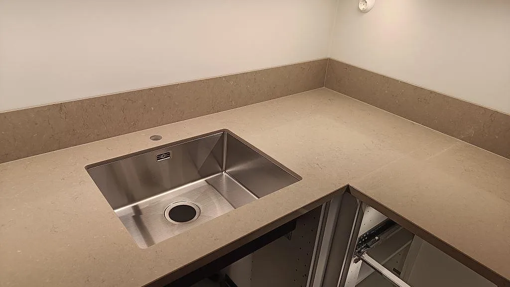 L-formad köksbänkskiva i polerad Silestone Coral Clay med rostfri diskho och matchande stänkskydd i Göteborg.