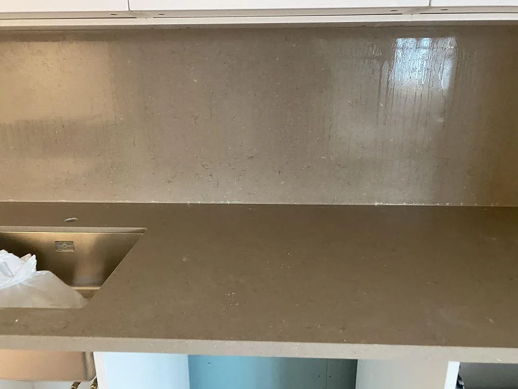 Underlimmad rostfri diskho i en polerad bänkskiva i Silestone Coral Clay med stänkskydd i samma sten i Grebbestad.