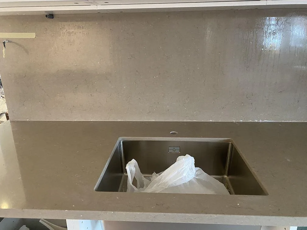 Detalj av underlimmad rostfri diskho i bänkskiva av Silestone Coral Clay i ett kök i Grebbestad.