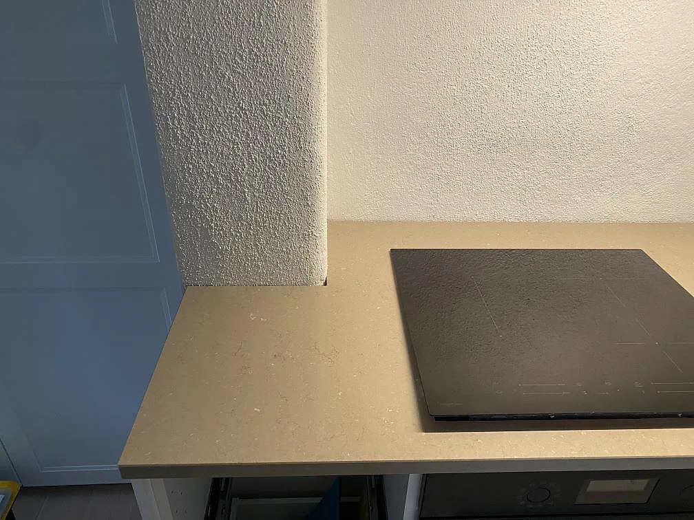 Köksbänkskiva i Silestone Coral Clay med induktionshäll och hörnskarvning mot vägg i ett kök i Grebbestad.