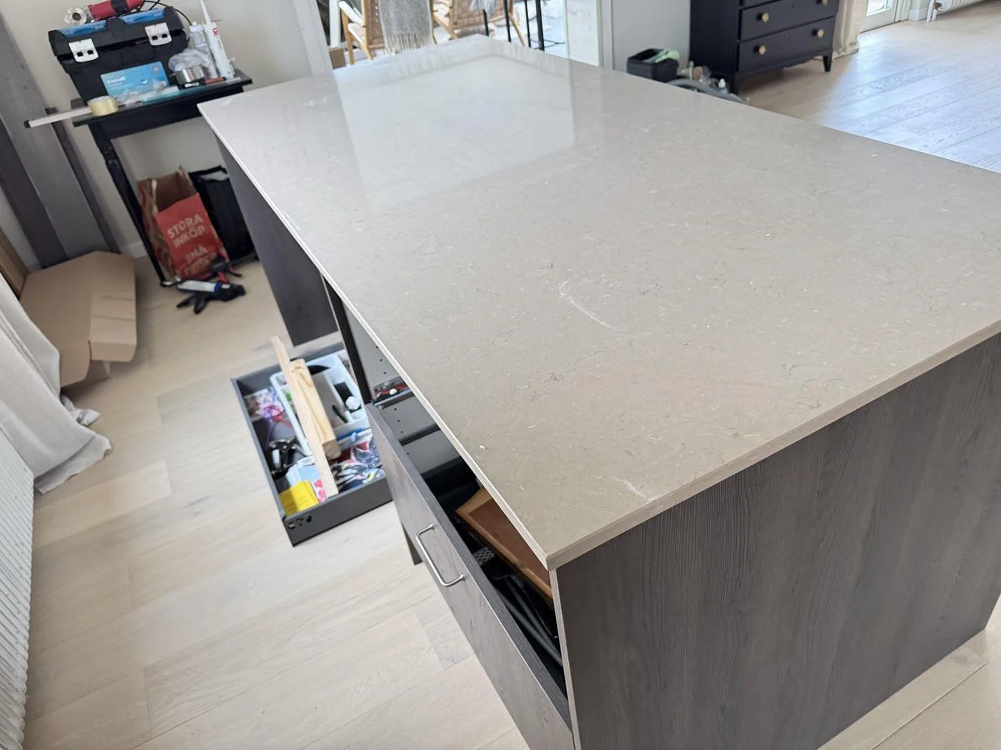 Polerad Silestone Coral Clay kompositskiva på köksö sedd från arbetsytan i Gullbrandstorp.