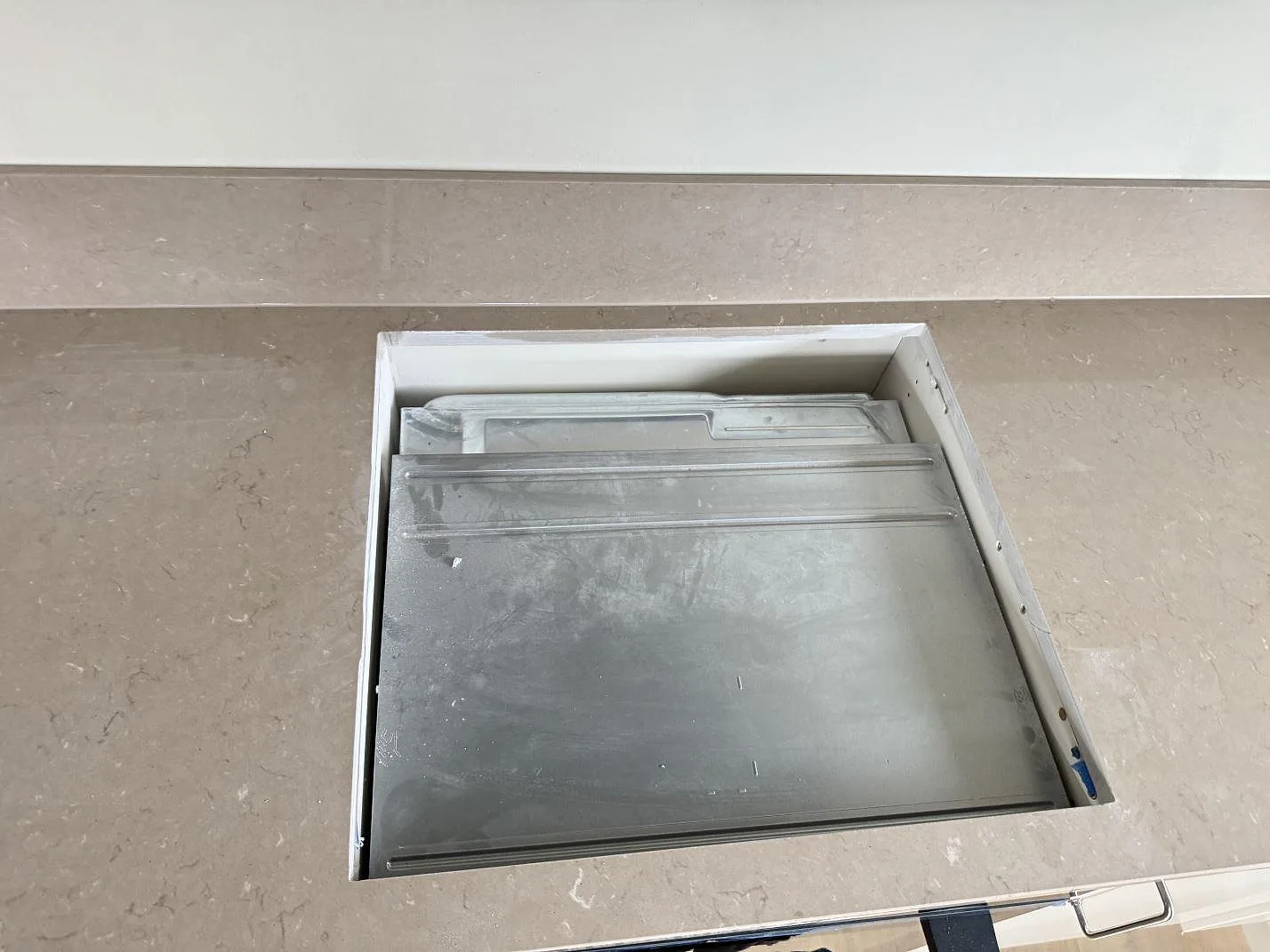 Detalj av hällurtag i polerad Silestone Coral Clay komposit med stänkskydd bakom i Gullbrandstorp.