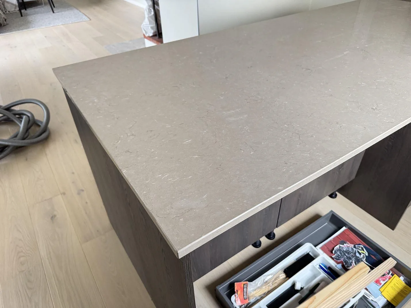 Närbild av polerad Silestone Coral Clay bänkskiva på köksö med ljus ådring i Gullbrandstorp.