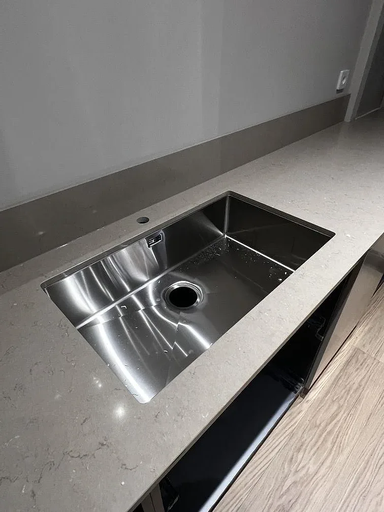 Underlimmad rostfri diskho med separat blandarhål i en köksbänkskiva i Silestone Coral Clay i Hässleholm.