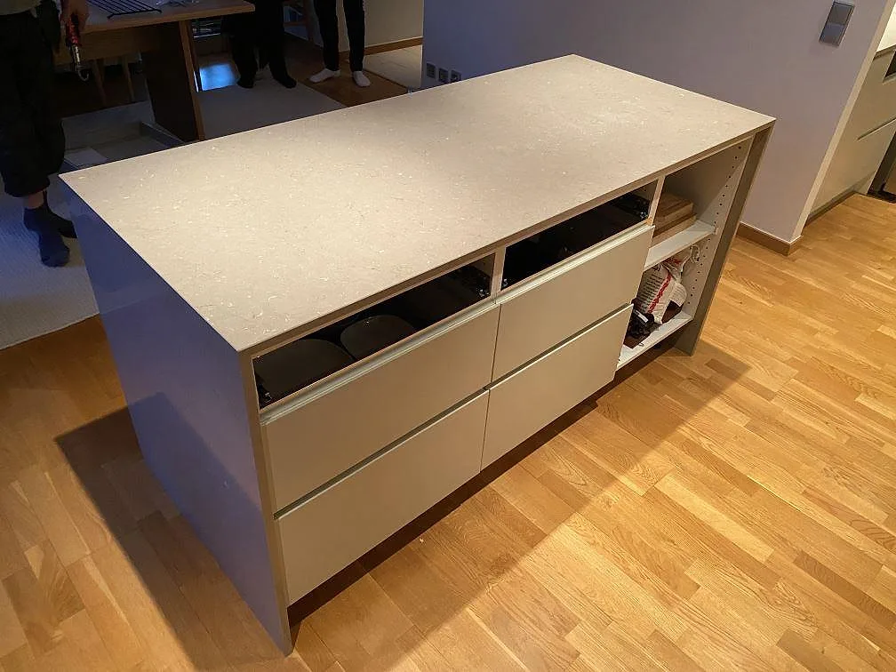 Polerad köksö i Silestone Coral Clay, kvartskomposit, monterad på vita köksstommar i Hässleholm.