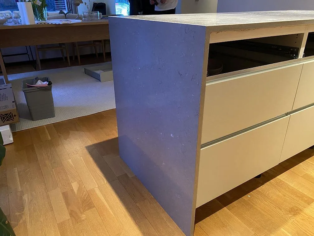 Gavelvy av köksö i polerad Silestone Coral Clay, med stenens kant och öppna köksstommar i Hässleholm.