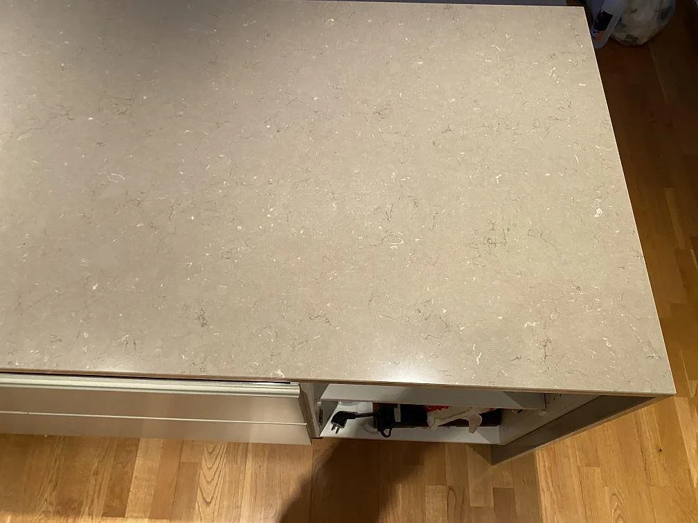 Detalj av köksö i polerad Silestone Coral Clay med synlig kant och ljus kvartskomposit i Hässleholm.