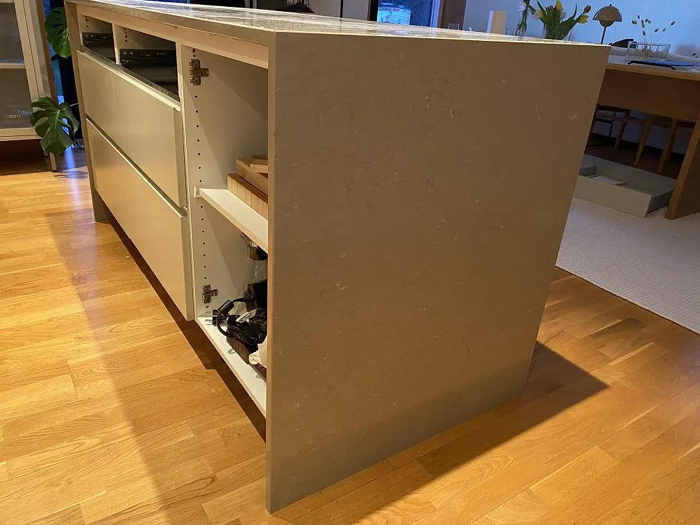 Sidovy av köksö med polerad Silestone Coral Clay och öppna stommar under montering i Hässleholm.