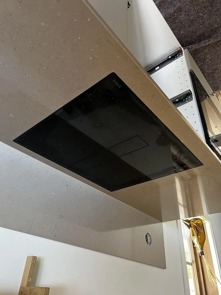 Infälld induktionshäll i en polerad köksbänkskiva av Silestone Coral Clay i Heberg.