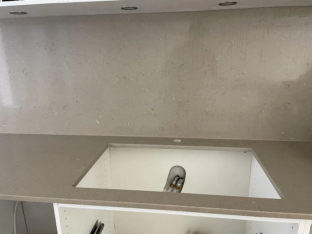 Närbild på polerad Silestone Coral Clay bänkskiva med öppning för underlimmad diskho och 12 mm stänkskydd i Helsingborg.