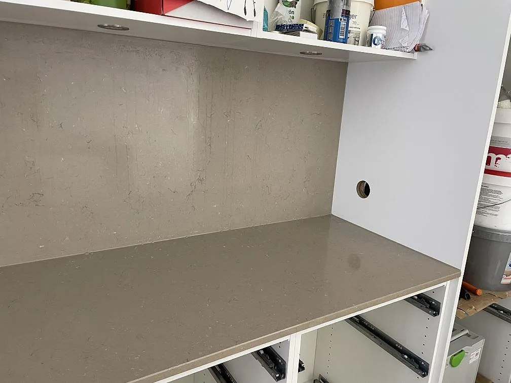 Polerad Silestone Coral Clay bänkskiva med utskuren diskhoöppning och varm gråbeige stenbild i Helsingborg.